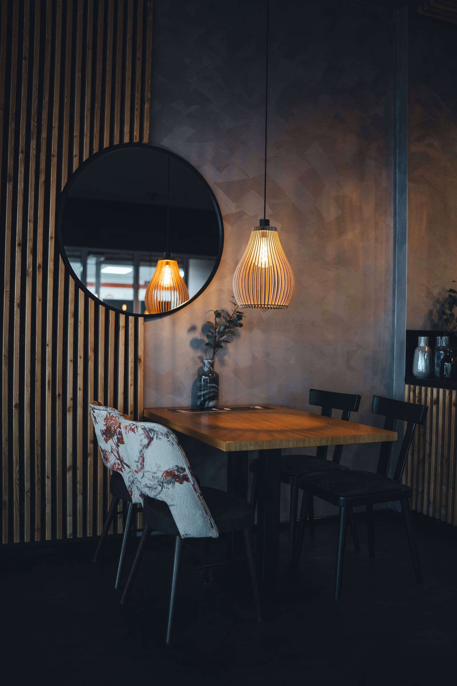 Mesa para dois junto à parede ripada, à noite