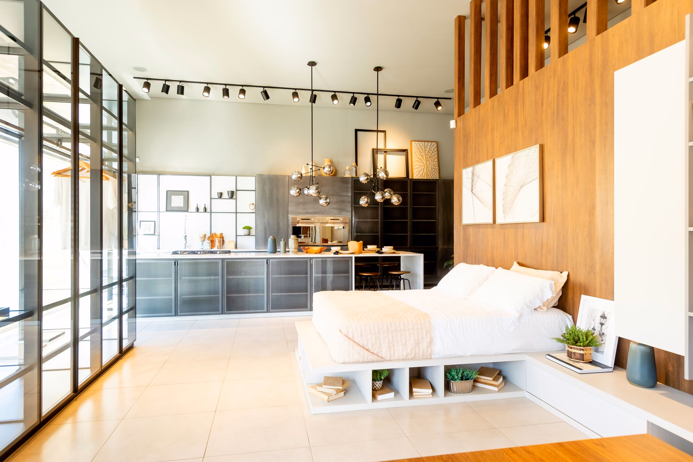 Dormitório montado no showroom, com painel ripado de madeira e nichos na base da cama